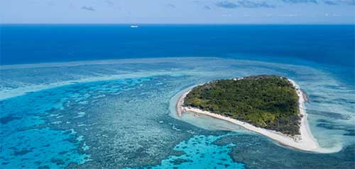 A green island with white beaches in deep blue sea