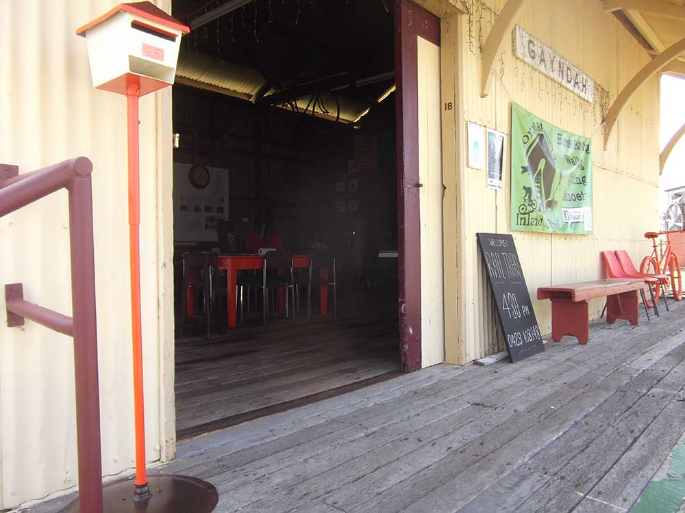 letter box with orange stand on a shed landing with wooden floor